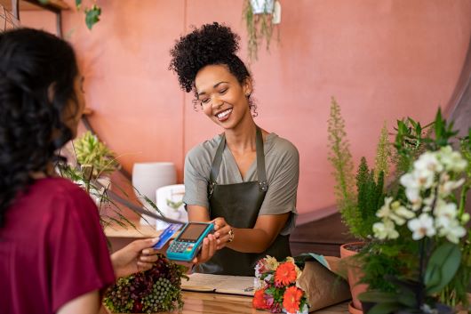 Woman holding credit card machine for a customer