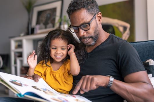 Father reading to daughter