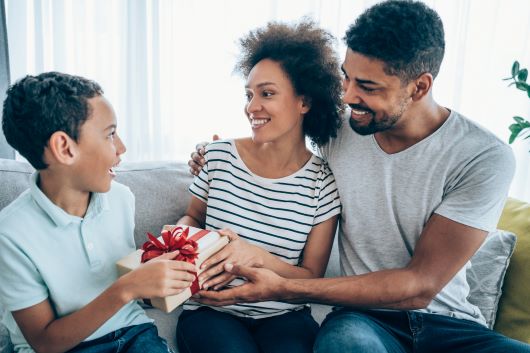 Pareja dando regalo a hijo