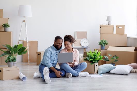 Pareja mirando una computadora en el piso