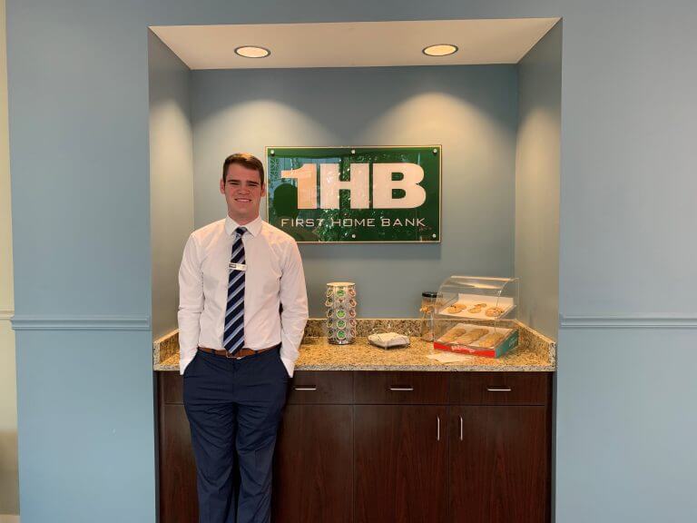 Young man standing in front of BayFirst sign